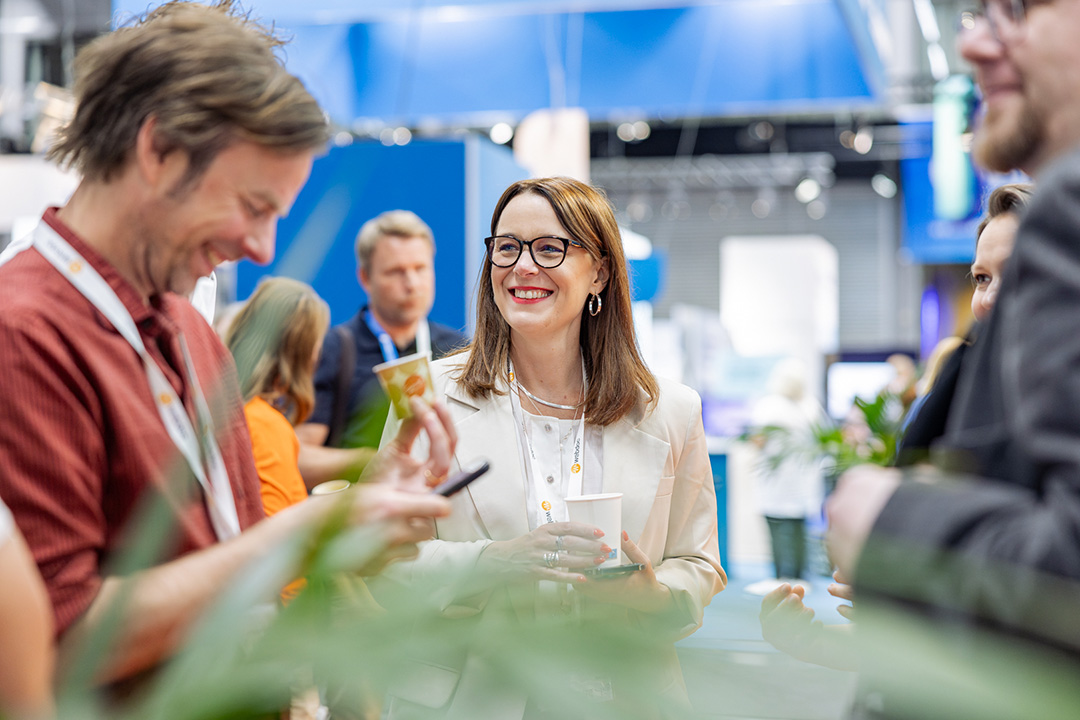 Tre personer pratar med varandra i mässan